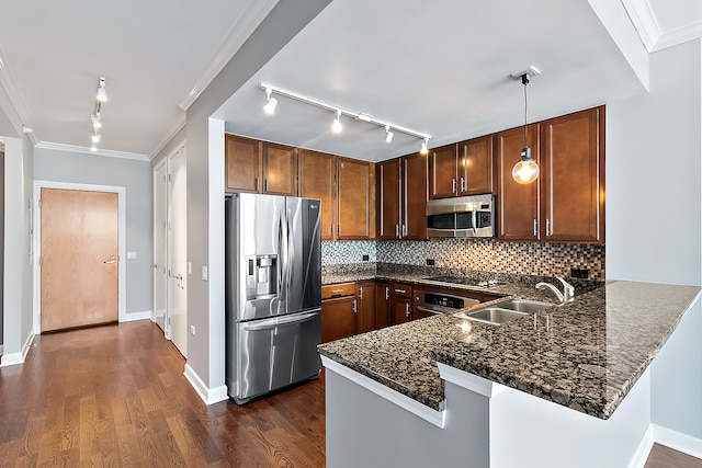 kitchen with backsplash, appliances with stainless steel finishes, rail lighting, dark wood-type flooring, and kitchen peninsula