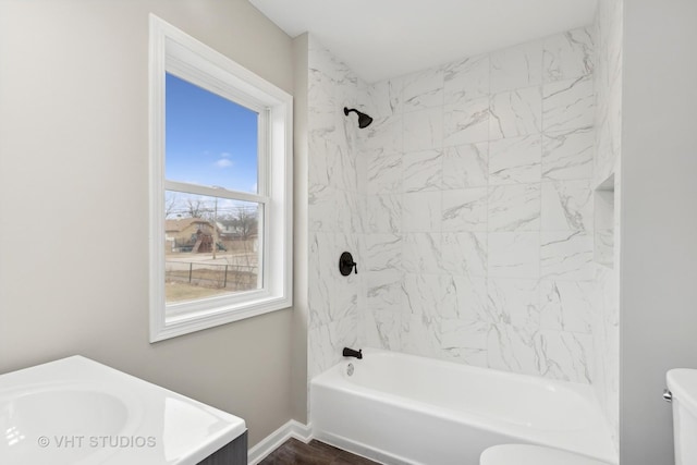 full bathroom with tiled shower / bath combo, vanity, and toilet