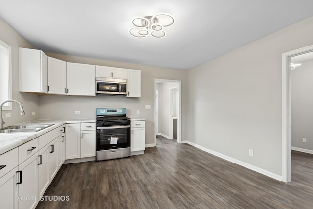 kitchen featuring appliances with stainless steel finishes, sink, dark wood-type flooring, and white cabinets