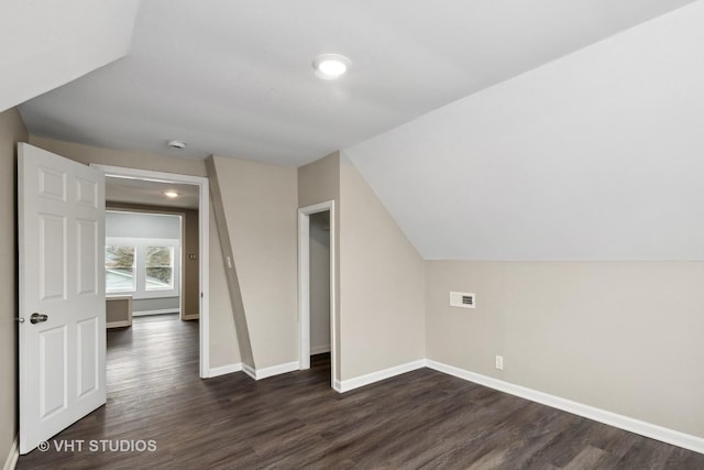 bonus room featuring dark wood-type flooring and vaulted ceiling