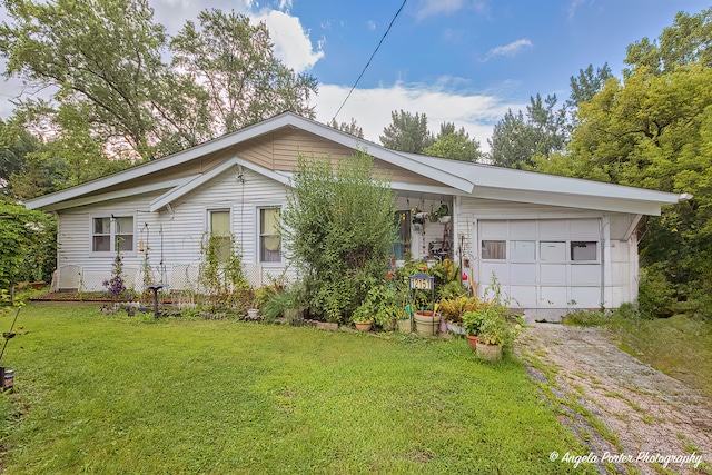 single story home with a garage and a front lawn