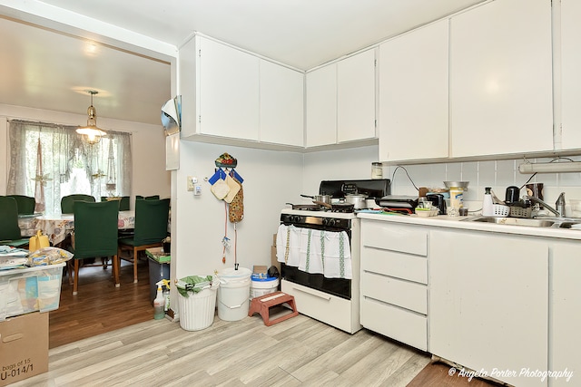 kitchen featuring decorative backsplash, light hardwood / wood-style flooring, white cabinets, and white gas range oven