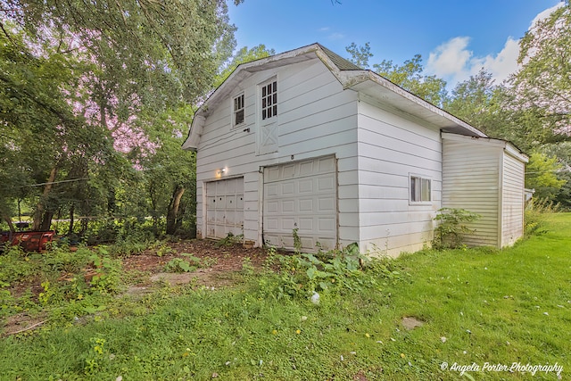 view of side of home featuring a yard and a garage