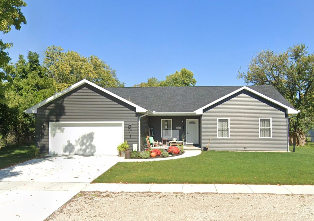 ranch-style house featuring a front yard and a garage