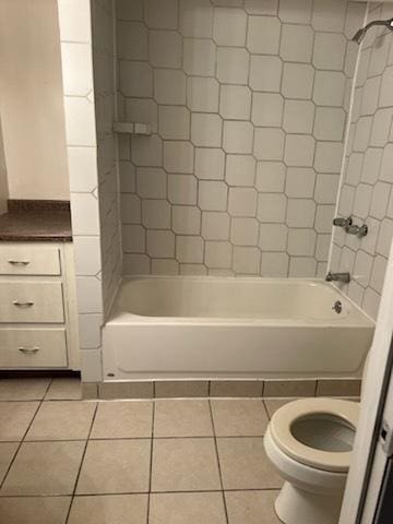 bathroom featuring shower / washtub combination, toilet, and tile patterned floors