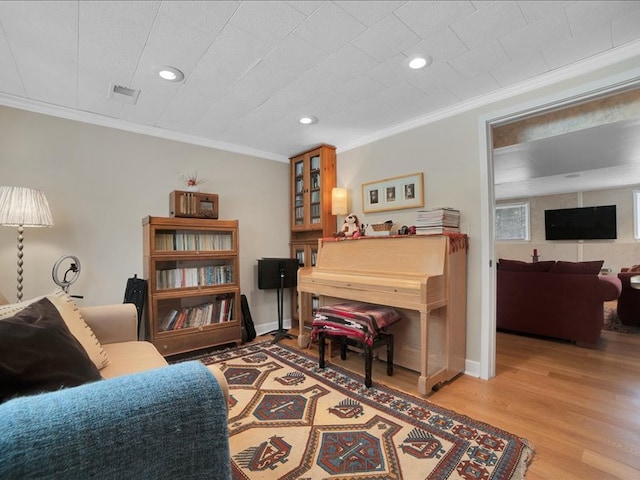 sitting room with light hardwood / wood-style floors and ornamental molding