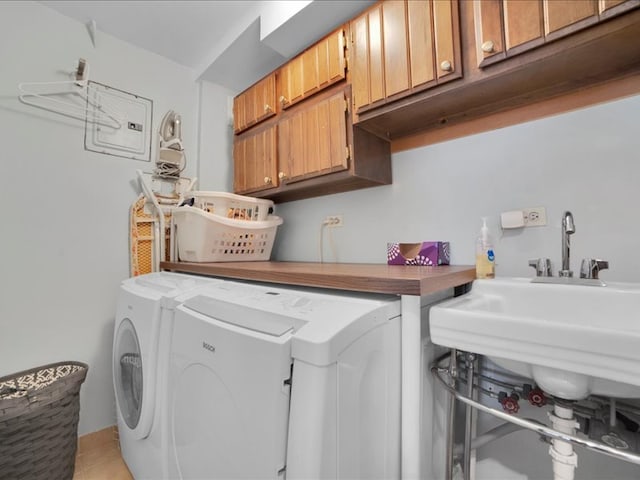 laundry area with light tile patterned floors, washing machine and dryer, and cabinets