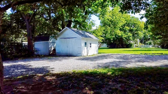 view of side of home with a storage unit and a yard