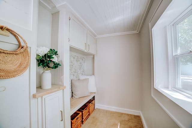 mudroom with crown molding and light tile patterned flooring