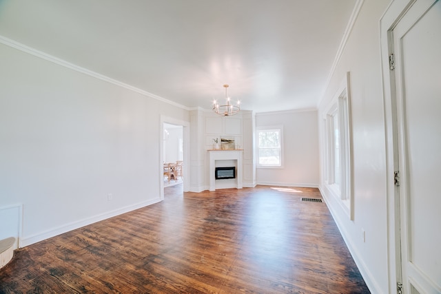 unfurnished living room with hardwood / wood-style floors, an inviting chandelier, and ornamental molding