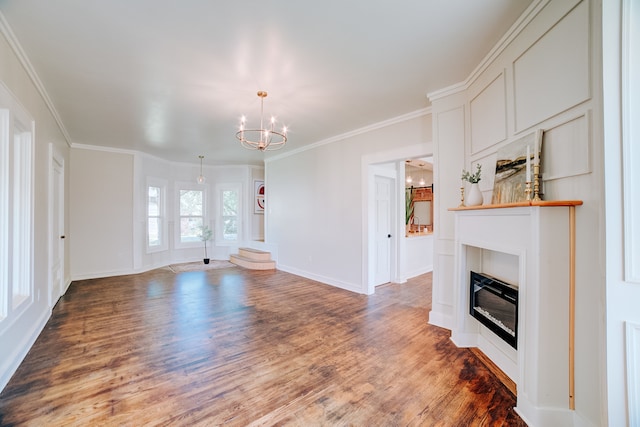 unfurnished living room featuring hardwood / wood-style flooring, ornamental molding, a tile fireplace, and a chandelier