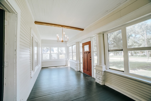 unfurnished sunroom with ornate columns, a chandelier, and a healthy amount of sunlight