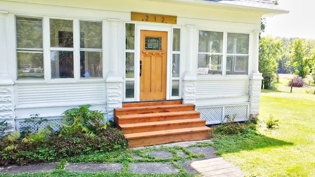 doorway to property with a yard