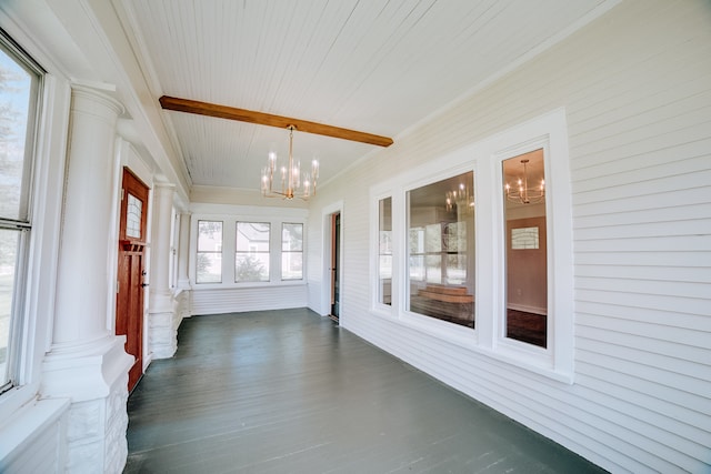 unfurnished sunroom with ornate columns and a notable chandelier