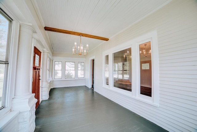 unfurnished sunroom with wooden ceiling, decorative columns, a notable chandelier, and beamed ceiling