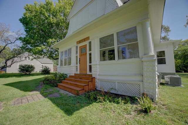 entrance to property with central AC and a yard