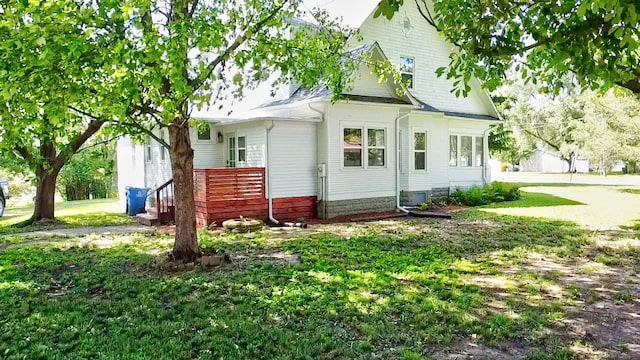 back of house featuring central AC unit and a lawn