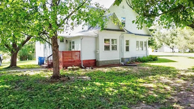 rear view of property featuring a lawn and cooling unit