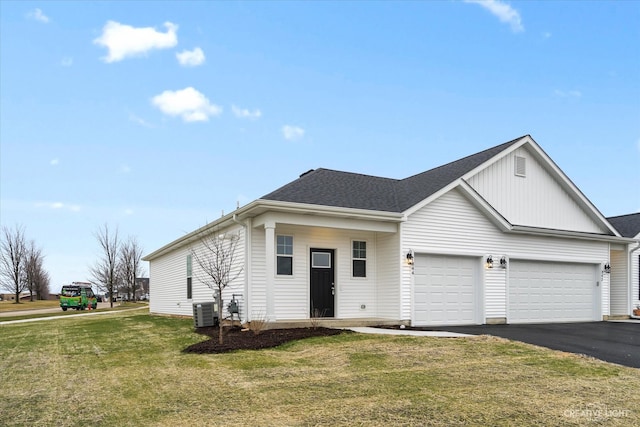 view of front of home with a garage, central AC, and a front yard