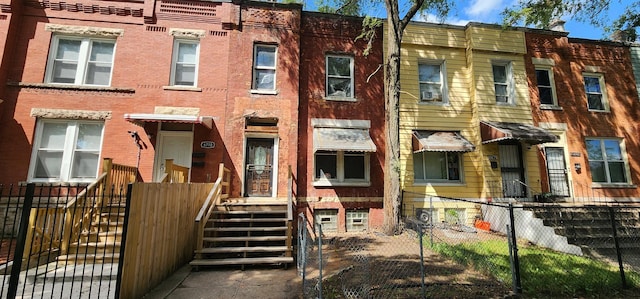 townhome / multi-family property featuring fence and brick siding