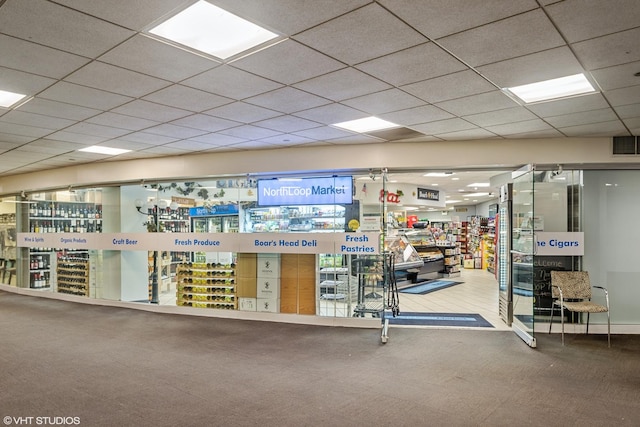 interior space with a drop ceiling, visible vents, and carpet floors