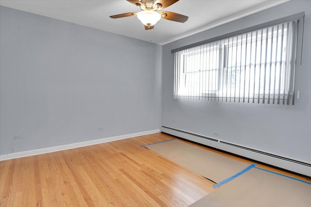 spare room featuring light wood-type flooring, baseboard heating, and ceiling fan