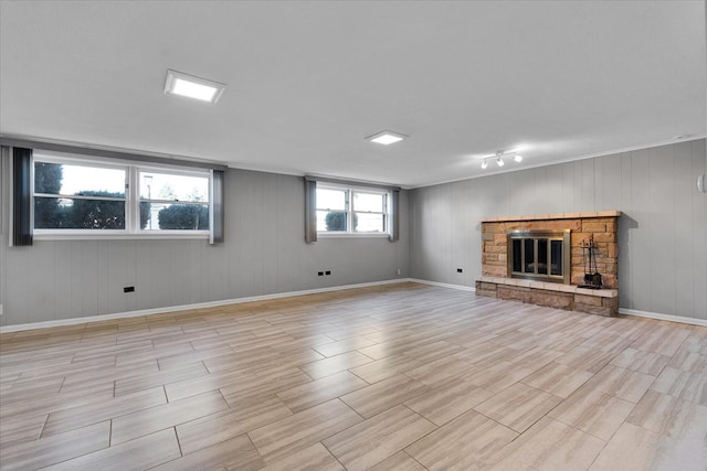 basement with a stone fireplace and wooden walls