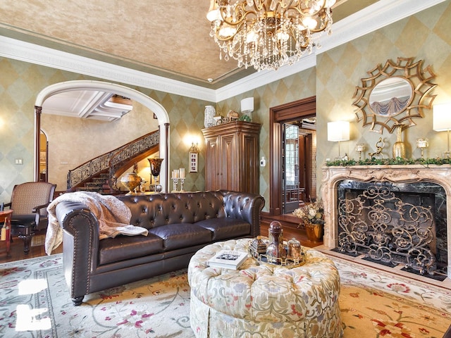 living area with wallpapered walls, arched walkways, a premium fireplace, ornamental molding, and wood finished floors