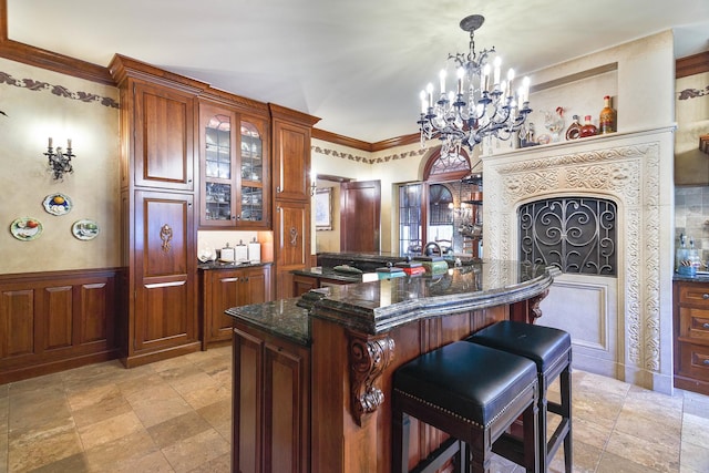 bar featuring a dry bar, a wainscoted wall, decorative light fixtures, crown molding, and a notable chandelier