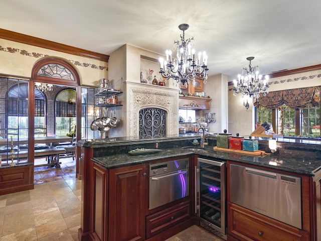 kitchen with stone tile floors, beverage cooler, a sink, dark stone counters, and an inviting chandelier