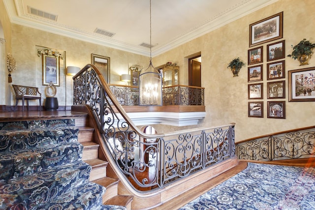 stairway featuring visible vents and crown molding