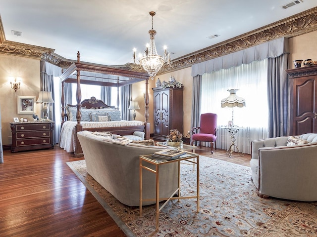 living room featuring an inviting chandelier, visible vents, and wood finished floors