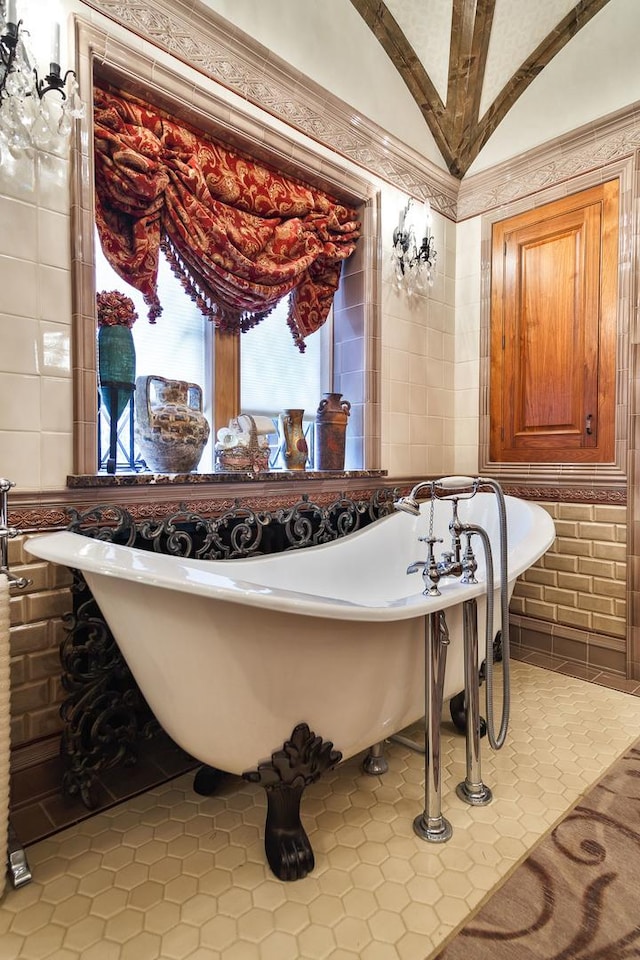 bathroom with a freestanding bath, tile walls, and tile patterned floors