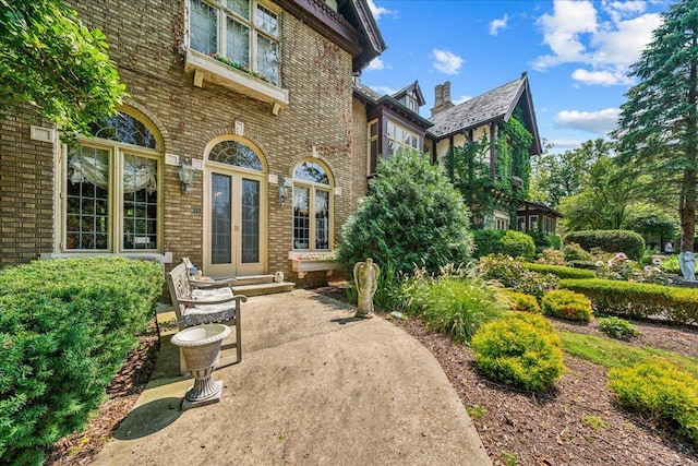 property entrance featuring french doors and brick siding