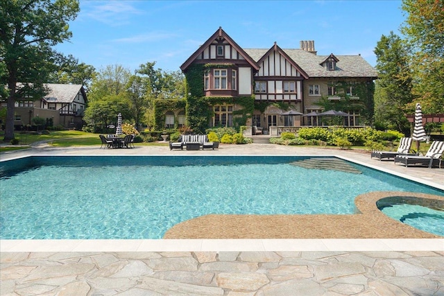 view of swimming pool featuring a patio area and a pool with connected hot tub