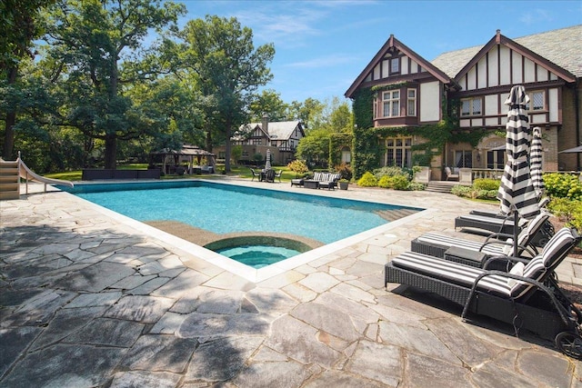 outdoor pool with a water slide, a patio area, a gazebo, and an in ground hot tub