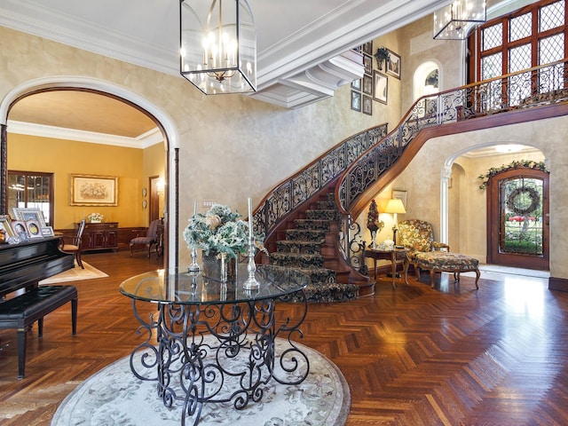 entrance foyer featuring arched walkways, crown molding, plenty of natural light, and an inviting chandelier