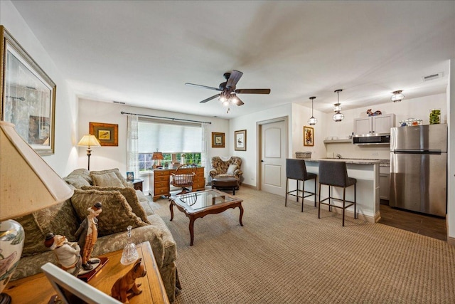 carpeted living room featuring a ceiling fan and visible vents