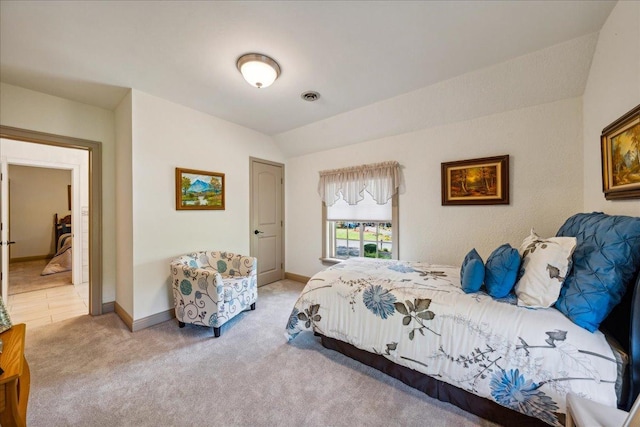 bedroom with light carpet, vaulted ceiling, visible vents, and baseboards