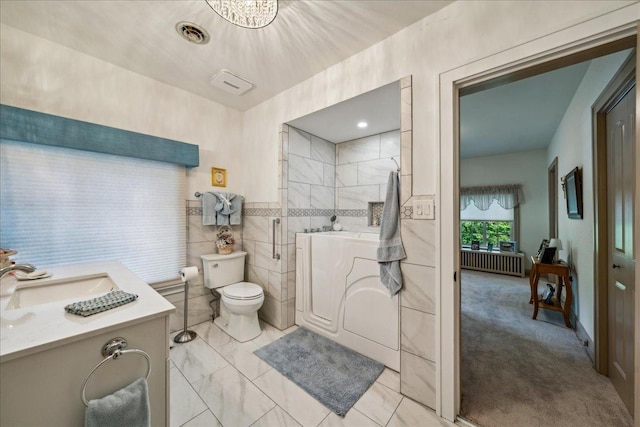 full bath with visible vents, toilet, radiator heating unit, vanity, and walk in shower