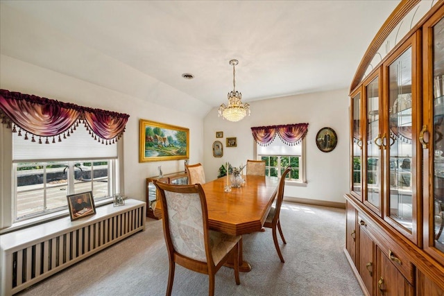 dining room with visible vents, baseboards, vaulted ceiling, and light colored carpet