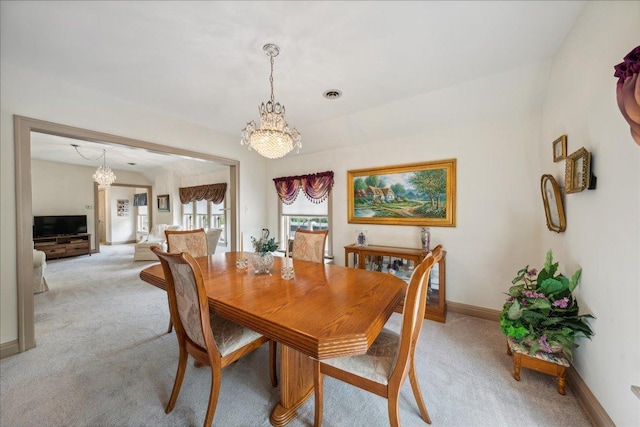 dining room featuring light colored carpet, a notable chandelier, visible vents, and baseboards