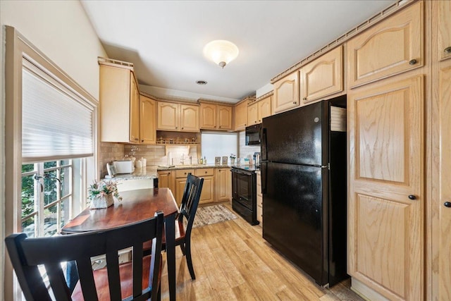 kitchen with light wood finished floors, black appliances, light brown cabinetry, and backsplash