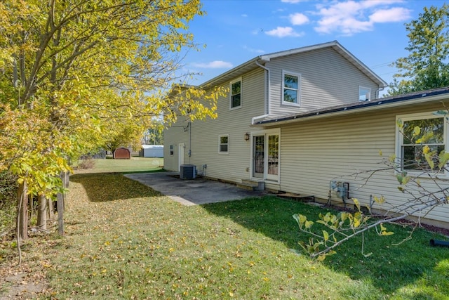 rear view of property featuring a yard, a patio area, and central air condition unit