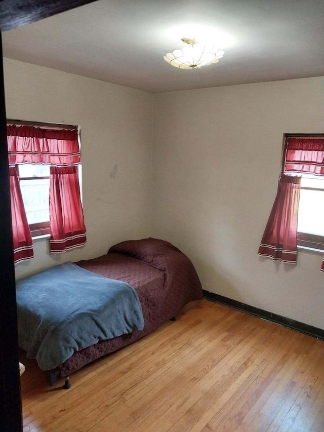 bedroom with wood finished floors and baseboards