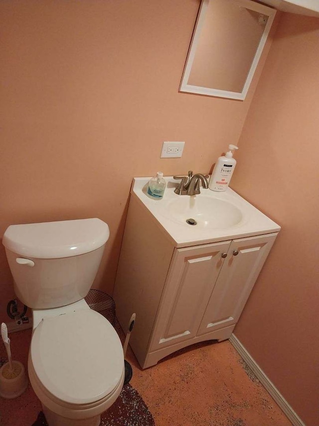 bathroom featuring toilet, vanity, and baseboards