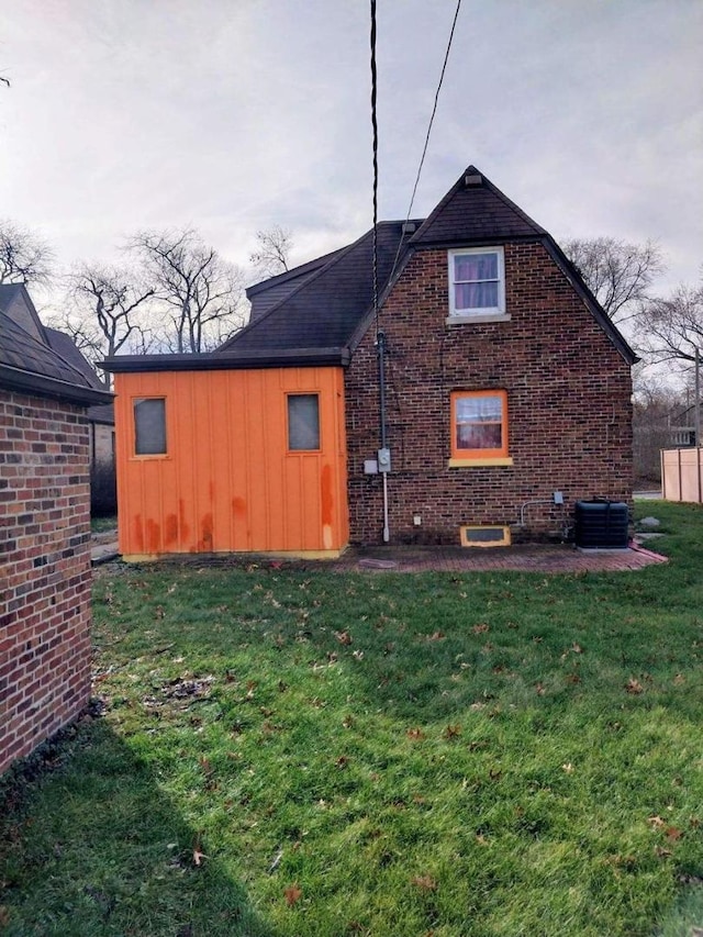 view of side of property featuring a lawn and cooling unit