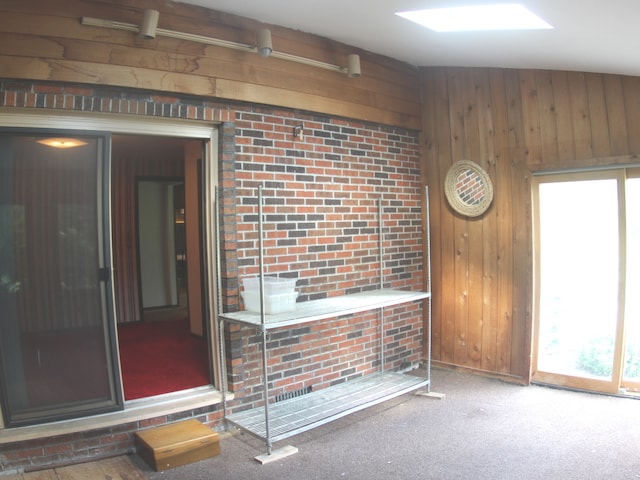 interior space featuring brick wall and wooden walls