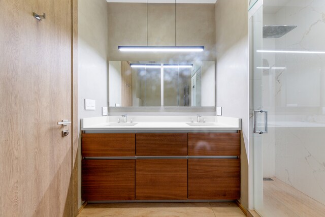 bathroom featuring an enclosed shower and vanity