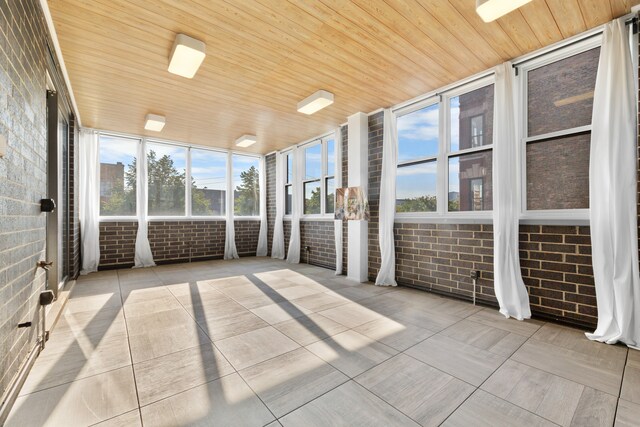 unfurnished sunroom with wood ceiling